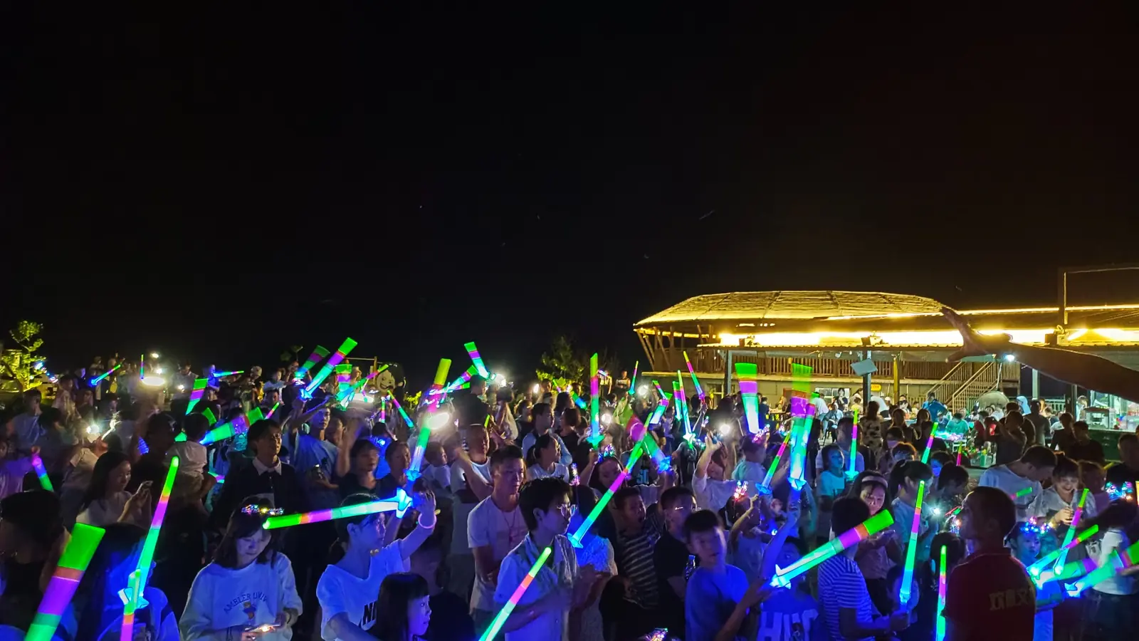 夜间观众挥舞荧光棒互动